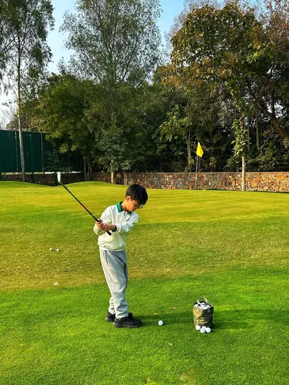 A young boy takes a confident swing on the chipping green, building skills for the future.