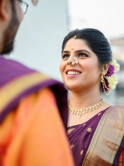 A candid moment between the bride and groom. Her traditional wedding look features a simple bun with flowers and natural makeup that enhances her happy glow.
