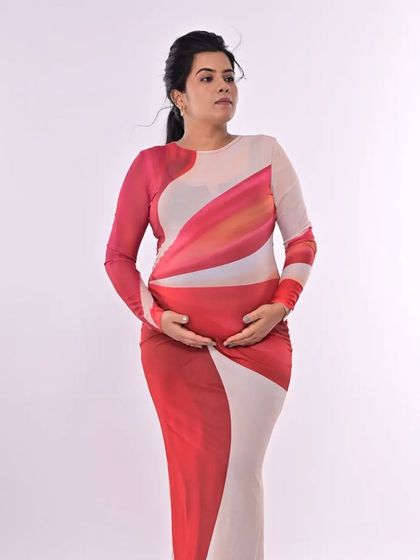 A full-body shot showing how the sleek ponytail and clean makeup create a very modern and fashionable maternity look.