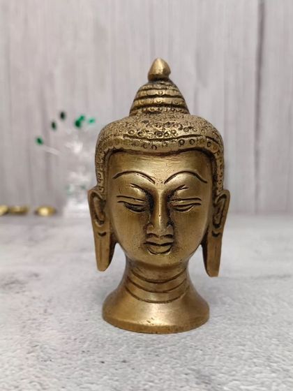 A brass Buddha head with a serene expression, ideal for creating a peaceful and meditative corner in your home.