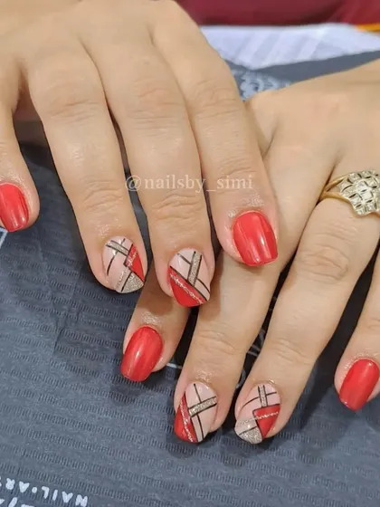 A geometric design with glittery lines on a nude base, paired with classic red nails.
