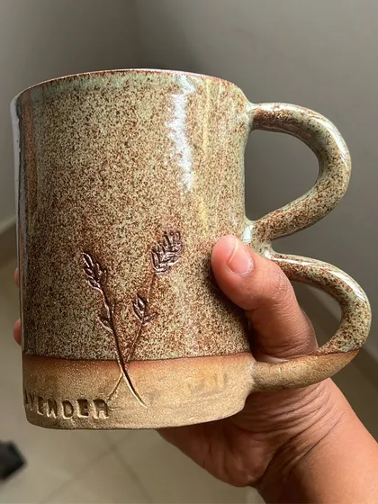 A beautiful hand-built mug with a unique double handle and delicate lavender impressions.