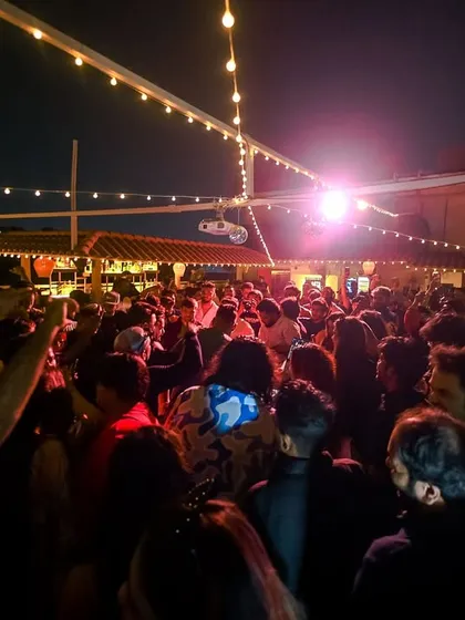 A wide shot of the rooftop venue for the Block Party. String lights and a packed dancefloor create the perfect atmosphere.