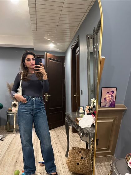 A mirror selfie showing a simple grey long-sleeve top paired with classic blue jeans. A perfect base for any casual outfit.