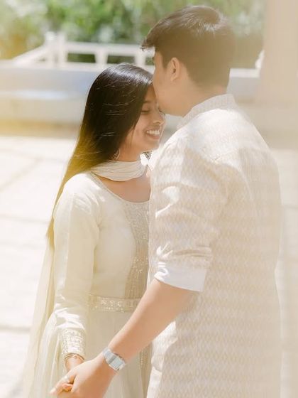 A bright, airy, and joyful pre-wedding portrait. The light-filled setting and the couple's happy expressions create a fresh and modern feel.