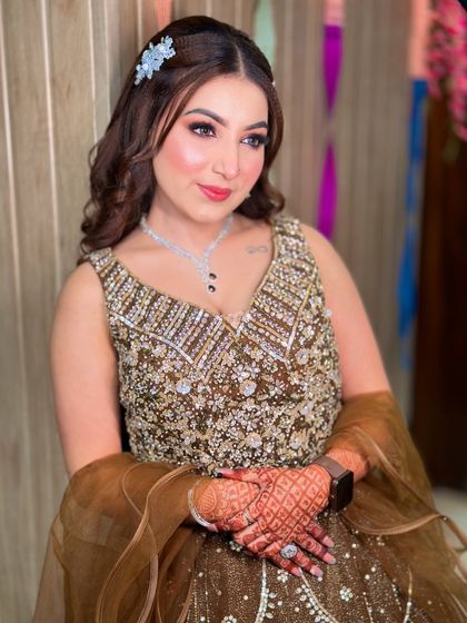Our beautiful engagement bride Kavya. We created a soft, romantic look with wavy hair and a subtle pink lip to match her brown lehenga.