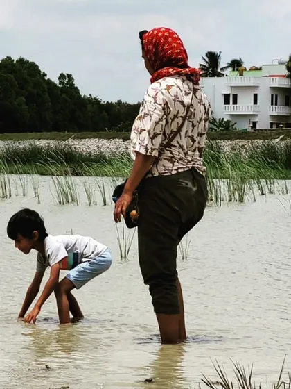 Wading into the cool water, a child begins the search for natural clay. This is a true sensory experience, feeling the texture of the earth and water. It is through such direct interaction that children build a real, lasting relationship with their environment.