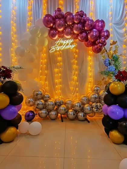 A unique floor-level balloon arch in metallic pink, silver, and black. This low-profile design is great for photos and creates a different look for your birthday party.