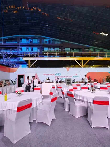 A wide view of the dining area set up inside the Air India aircraft hangar. This image demonstrates our ability to transform massive, unconventional spaces into fully functional and elegant event venues.
