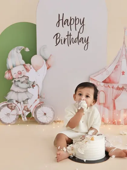 A taste of birthday fun. This shot captures the moment just before the real mess begins, with the birthday boy curiously tasting his cake. The simple, elegant setup with a circus tent background adds a touch of magic.