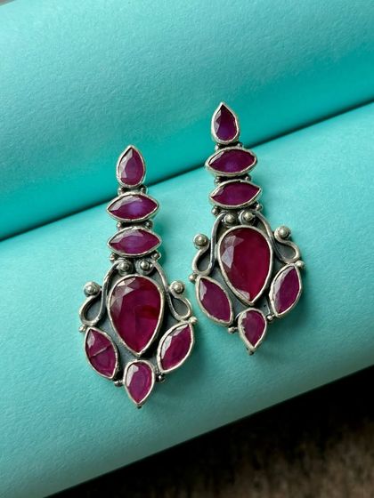Exclusive silver earrings with vibrant pink stones. The design is elegant and modern, perfect for enhancing your outfit of the day.