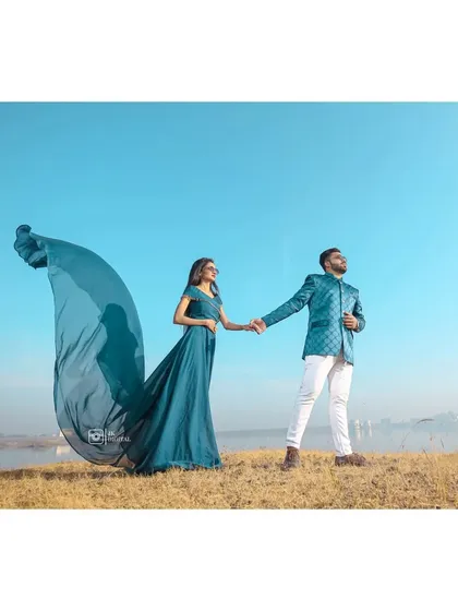 A windswept, romantic pose with the gown's fabric catching the breeze. This style of pre-wedding photography creates a sense of movement and epic romance.