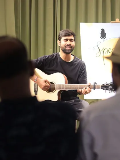 A musician serenades the audience at a "Speaking Souls" open mic.