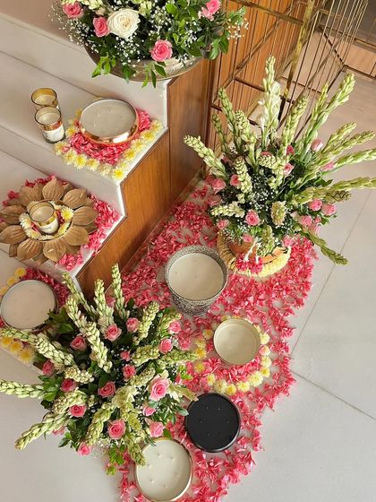Decorating a staircase with scattered flower petals, candles, and floral arrangements. This is a beautiful way to carry the festive theme throughout a multi-level home, seen here for a Diwali celebration.