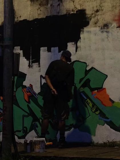 An artist from the crew working on a green graffiti piece at night. Jam sessions often go on for hours as we all get lost in the process of painting.