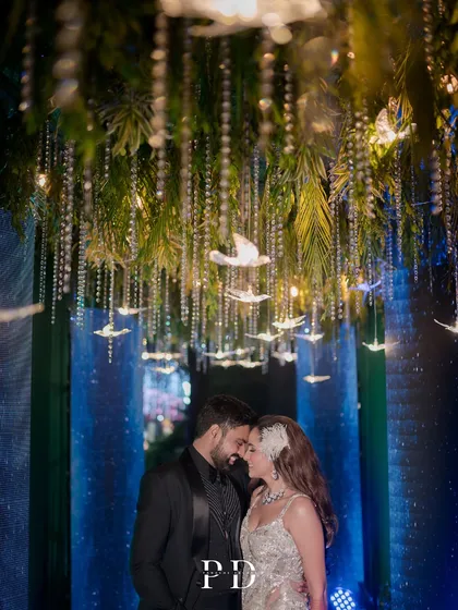 We love designing unique themes that tell your story. For this celestial sangeet, we created an enchanted pathway with hanging crystal birds and atmospheric lighting, making the couple's entrance feel like a walk through the stars.