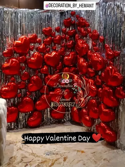 To make a bold romantic statement, I can design high-impact backdrops like this one. A wall filled with red heart-shaped foil balloons against a silver tinsel curtain creates a dramatic and fun photo opportunity for Valentine's Day or a proposal.
