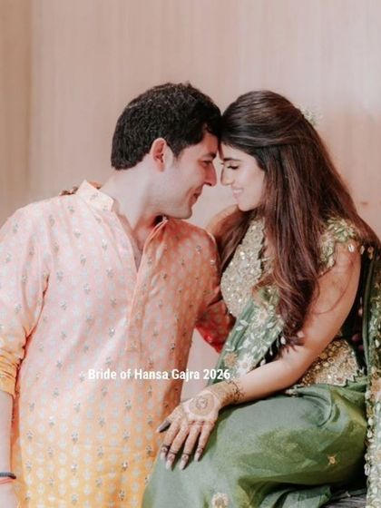 A romantic moment between a couple during their mehendi ceremony. The bride's minimal mehendi looks elegant against her green outfit as she shares a quiet moment with her partner.