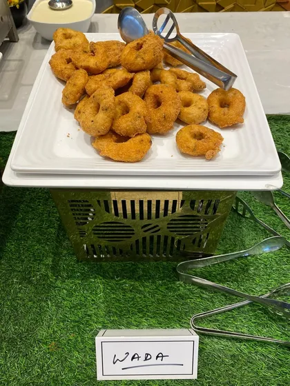 A platter of crispy Medu Vada, a savory South Indian fritter, ready to be served at a birthday party.