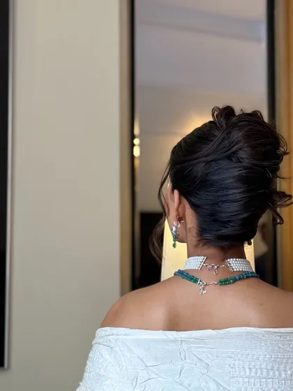 Another angle of the textured high bun, showing how the interwoven pieces create depth and visual interest. The soft tendrils around the face add a touch of romance to this formal hairstyle.