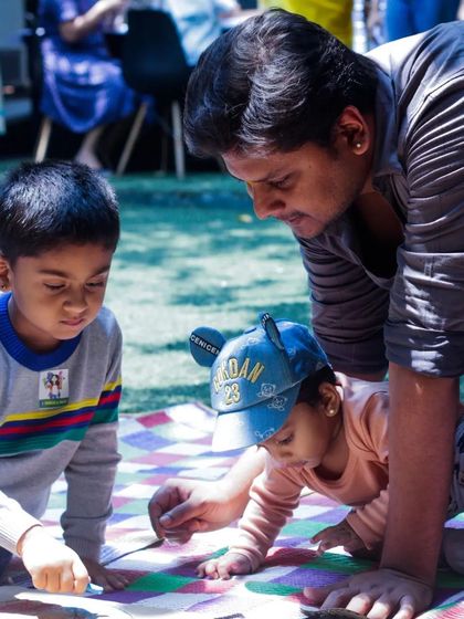A dad and his kids, deep in concentration during a craft activity at our outdoor Father's Day event. It’s wonderful to provide a space where families can slow down and enjoy a creative project together.
