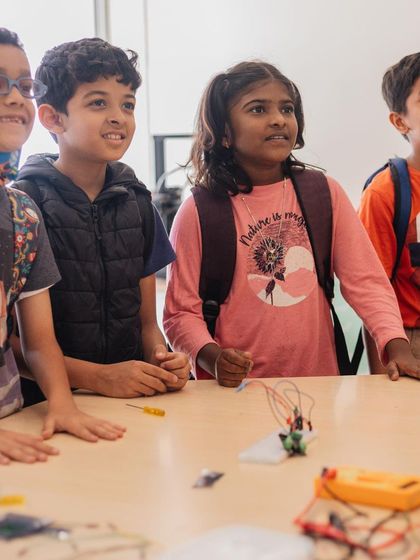 The moment of truth. A group of students watches in anticipation as their robotic creation comes to life, a shared experience of excitement and accomplishment.
