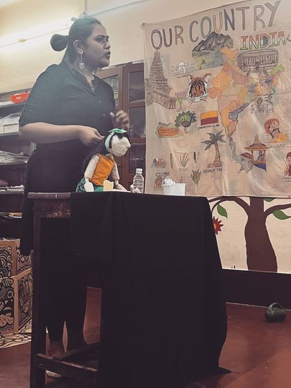 Performing with a hand puppet at a community center. Behind me is a hand-drawn map of India, which we sometimes use to tell stories about different parts of our country.