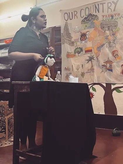 Our puppeteer using a hand puppet to tell a story against a backdrop of a map of India, making the session both fun and educational.