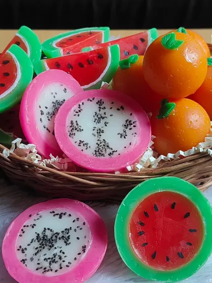 A closer look at the basket of fruit soaps, showing the detail in the watermelon and dragon fruit slices.