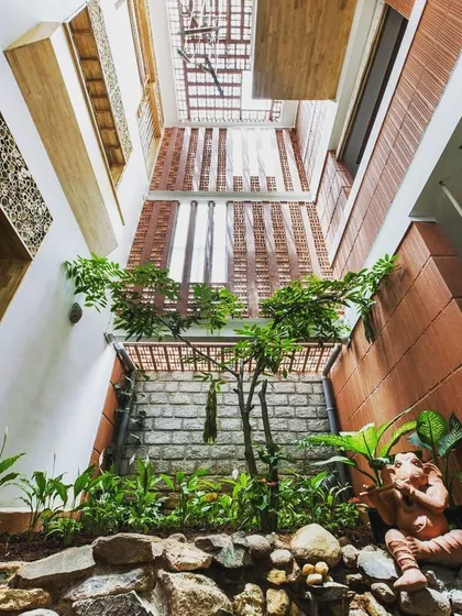 This is a view looking up from an internal courtyard. The design brings greenery and natural light deep into the home, with plants at the base and open sky above. It’s a great way to ensure your home feels connected to nature.
