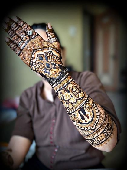 A stunning full arm design with bold, modern elements. The large central motif and surrounding patterns create a very striking look.