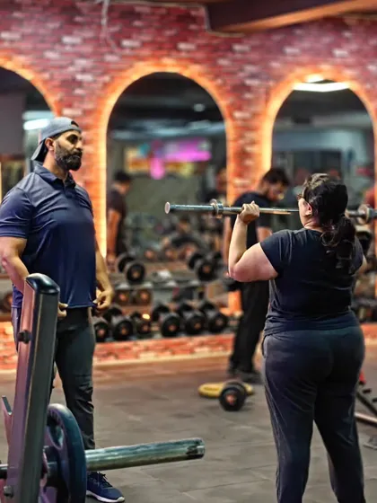 Here, I’m supervising a client during an overhead press. Proper technique is key to building shoulder strength without compromising the joints, and my job is to be your second set of eyes.