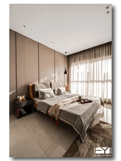 A spacious and serene bedroom with a neutral color palette and a floor-to-ceiling panelled wall. The natural light from the large window creates a bright and airy feel, making the room a perfect modern retreat.