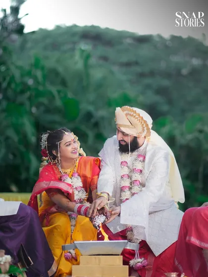 The couple participates in a traditional wedding ritual, sharing a smile. We are experts in documenting the sacred ceremonies of Maharashtrian weddings with care and precision.
