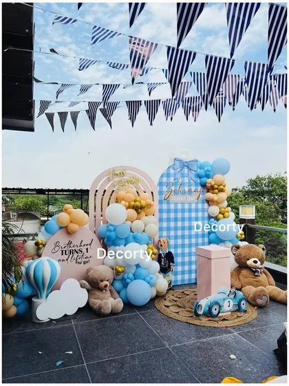 A wider angle of the rooftop teddy bear party, showing the festive bunting flags against the sky.