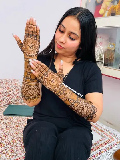 A client showing off the back of her hands, featuring a beautiful mandala design.