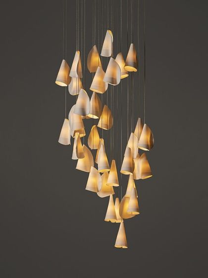 A studio shot of a large, spiraling installation of the Bocci 21 series, showcasing its delicate, cone-like porcelain forms.