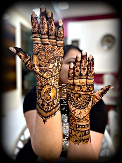 A playful pose showing two different back hand designs. One features a traditional palanquin, while the other has a beautiful peacock motif.