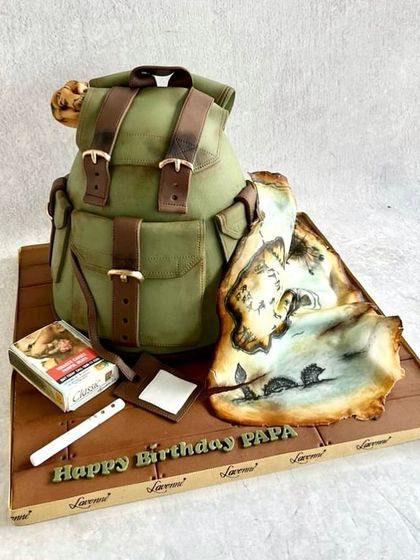 A birthday cake for a dad who loves the outdoors. This cake is a fully edible scene, featuring a sculpted backpack, a hand-painted map, and other little details that tell a story.