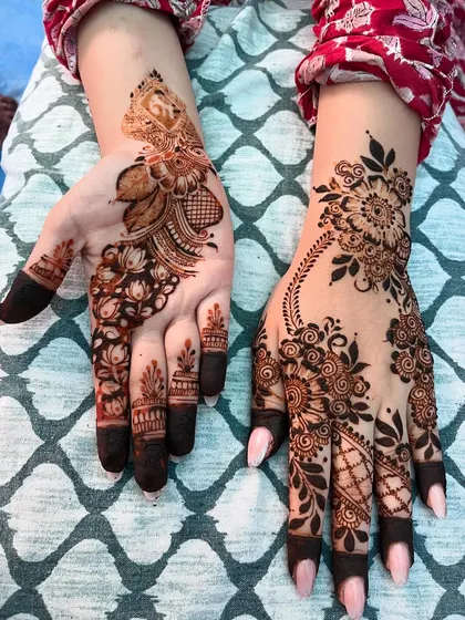 A view of both the front and back of the hands, showing how different patterns can be combined for a unique look. The palm features a traditional mandala while the back has a floral vine.
