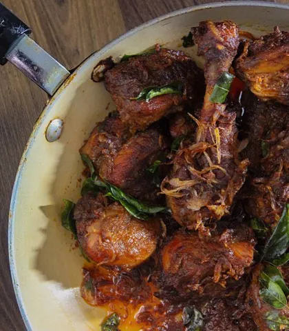 This is Chicken Roast, Amma's style. I learned to make it simply because I loved to eat it. It features succulent chicken pieces cooked in a thick, caramelized onion gravy, garnished with fried onions and curry leaves.