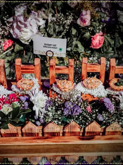 Our savory tarts are presented in a creative display of miniature wooden chairs, surrounded by fresh flowers. It's this attention to detail that makes our food setups unique.
