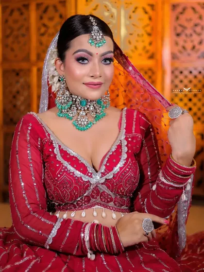 The bride lifts her sheer dupatta, creating a soft and dreamy effect in this portrait.