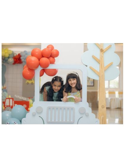 Two happy guests enjoying a photo-op inside a custom-built car prop.