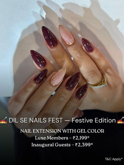 A dramatic and elegant set of stiletto nail extensions. This look features a deep burgundy gel color with nude accent nails and fine gold detailing for a touch of sophistication.
