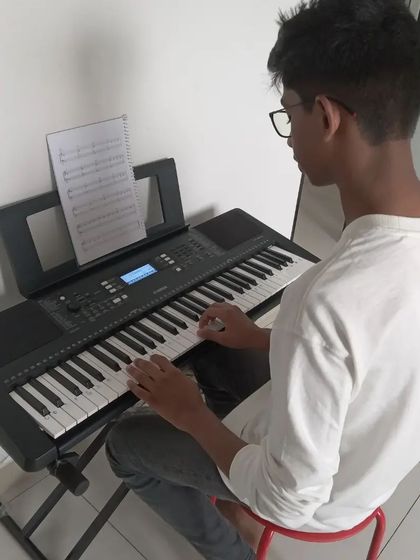 A student focused on his keyboard practice.