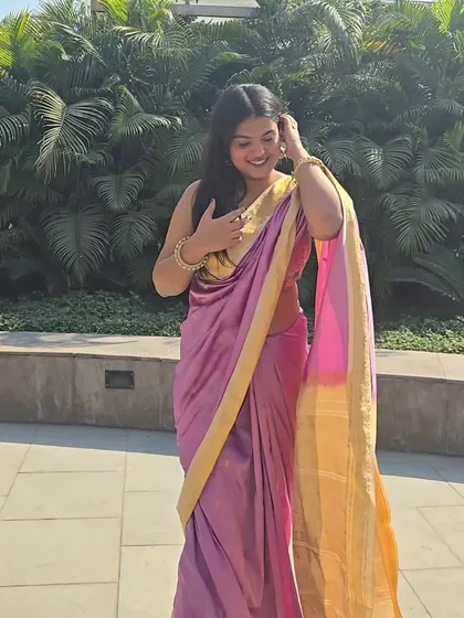 A candid smile while adjusting the drape. Styling is about feeling comfortable and happy in what you wear, and this look was all about that joy.