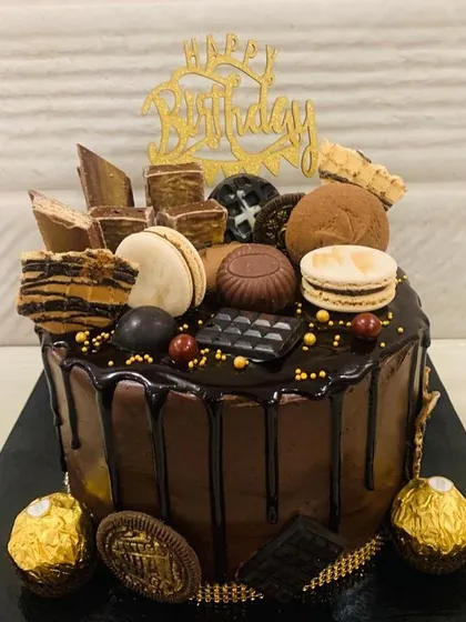 Love at first bite. This chocolate overload cake is a feast for the eyes and the palate, with a rich drip and a mountain of toppings.