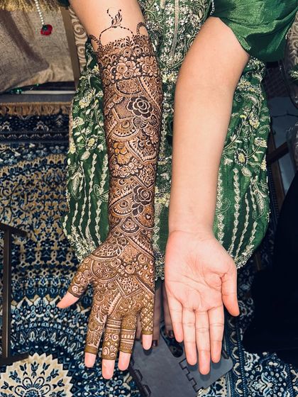 A full-arm Indian bridal design, shown with one arm bare to highlight the beautiful transformation.
