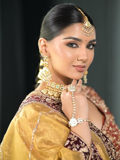 This shot shows the intricate hand jewelry and how it ties into the overall look. The makeup remains the star while complementing all the other elements.